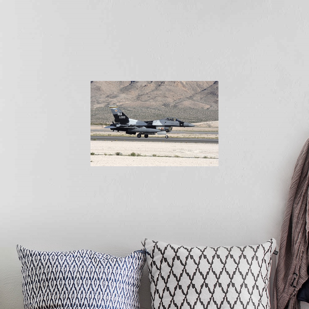 A bohemian room featuring An F-16C Aggressor jet landing on runway in Nevada.