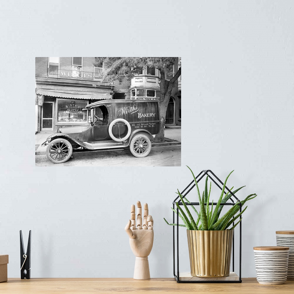 A bohemian room featuring A car with an advertisement for Wirth's Bakery in front of the store on H Street in Washington, D...