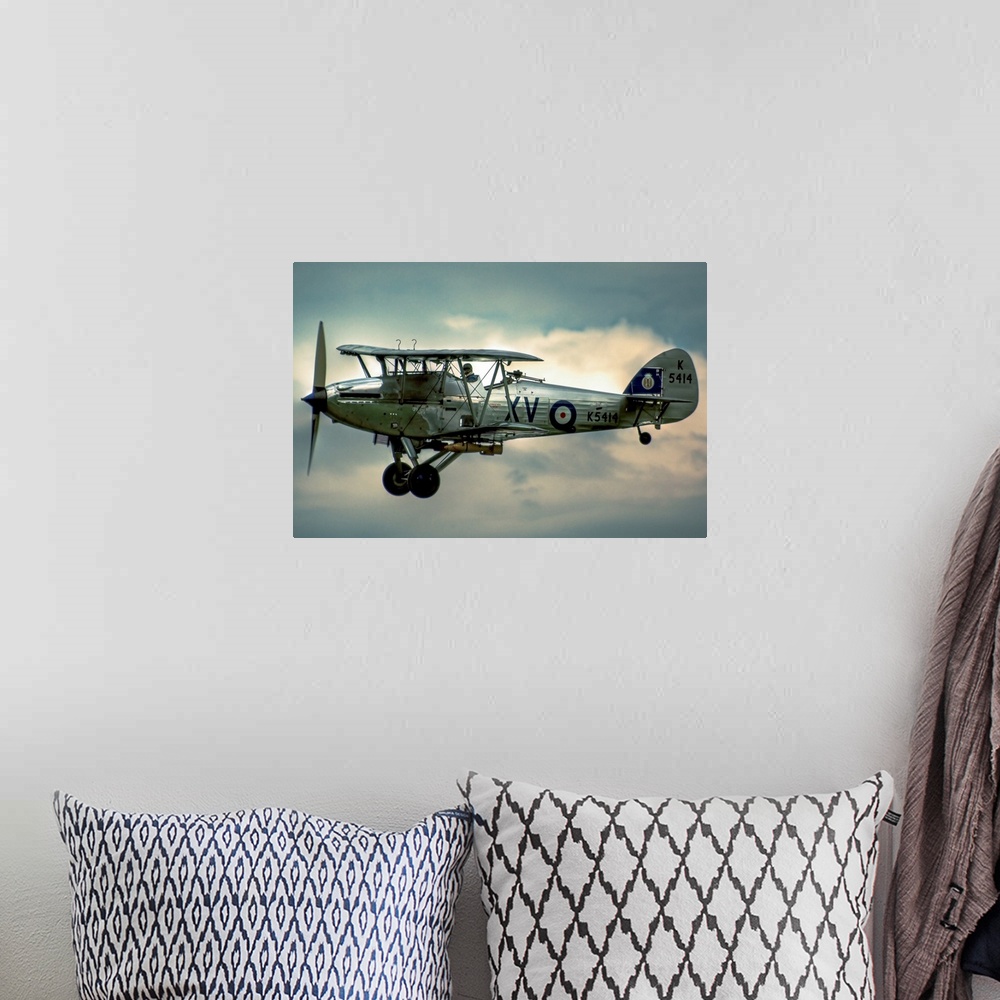 A bohemian room featuring A 1935 Hawker Hind flying on a cloudy day