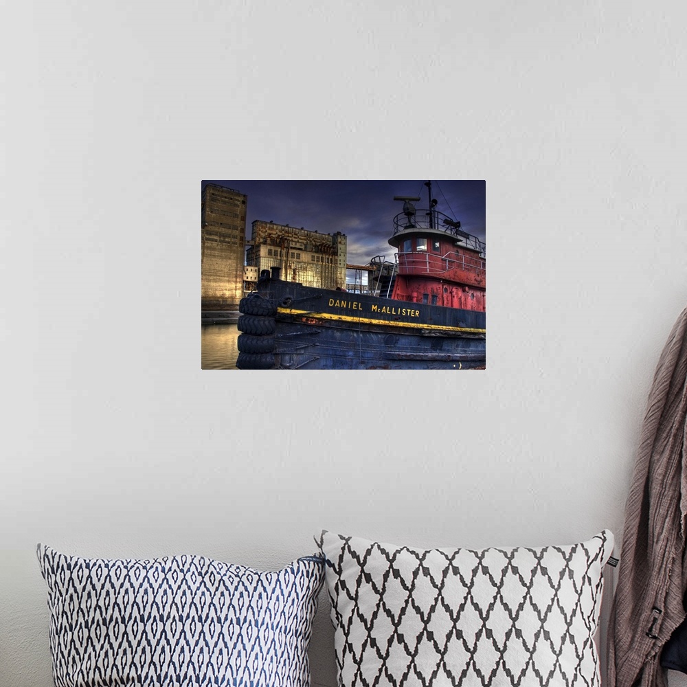 A bohemian room featuring An old tug boat near to industrial buildings