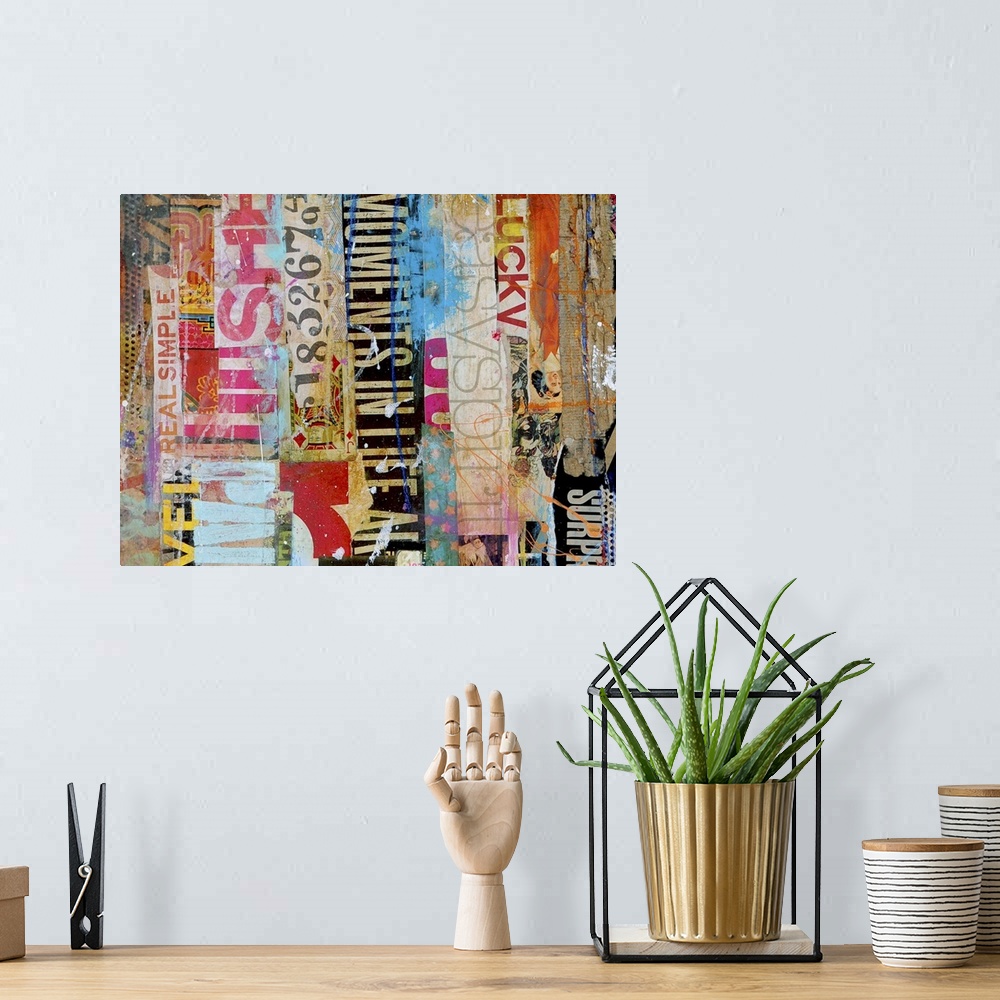 A bohemian room featuring Contemporary mixed media artwork composed of a variety of found text arranged vertically.
