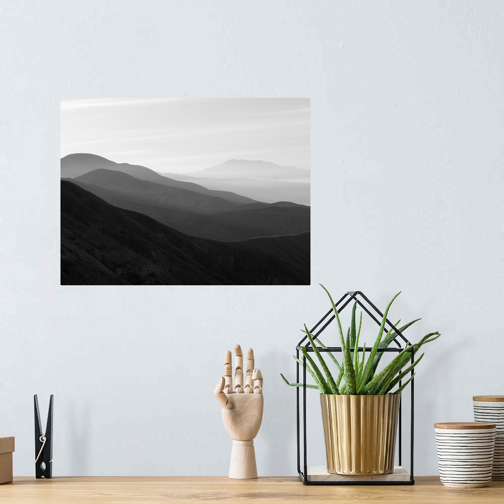 A bohemian room featuring A black and white photograph of a landscape of a silhouetted mountainous valley.