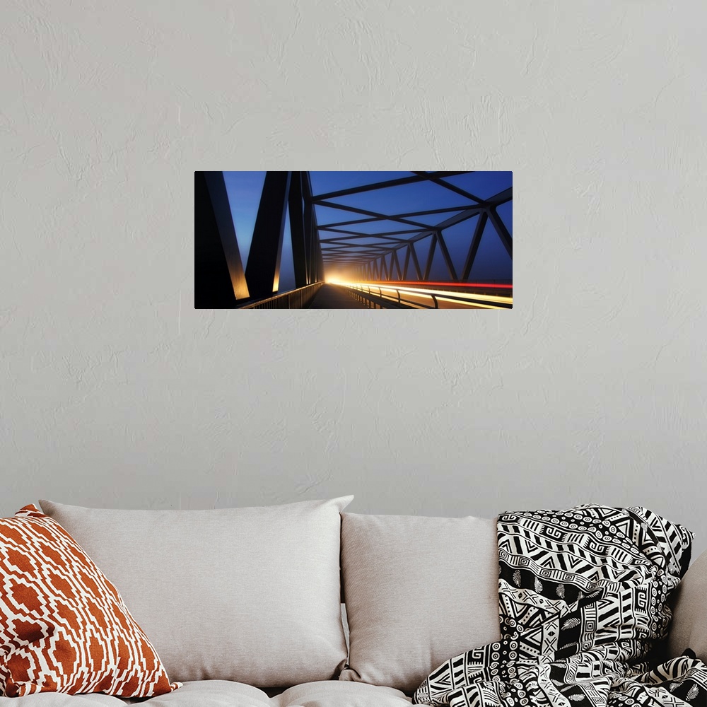 A bohemian room featuring Light trails on a bridge with cross beams forming simple shapes in the morning.