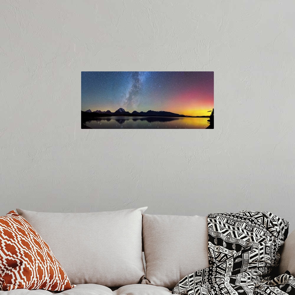 A bohemian room featuring Aurora Borealis and the Milky Way visible in the sky over a lake.