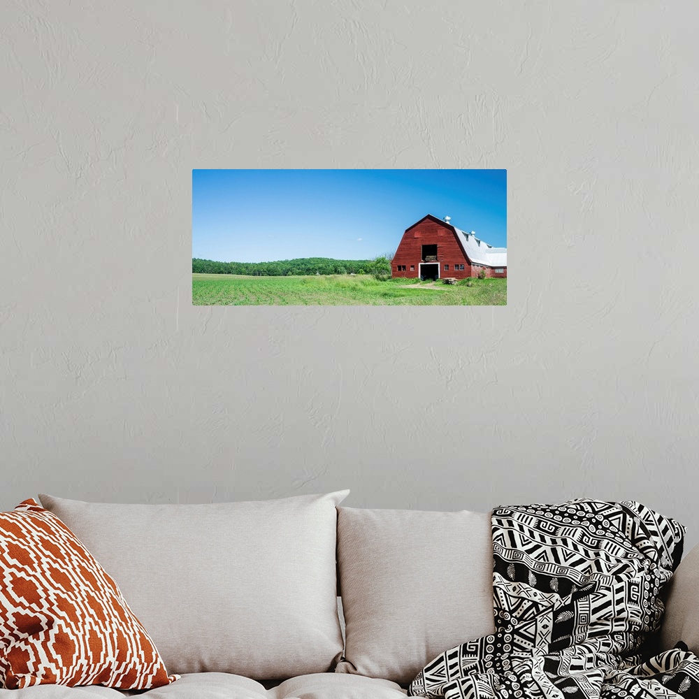 A bohemian room featuring A red barn, green fields, and blue sky of a classic Vermont family farm.