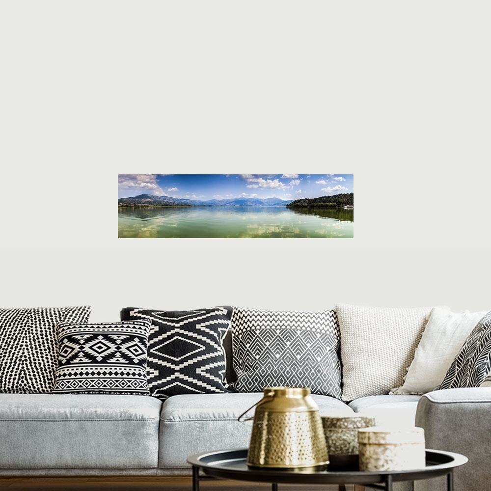 A bohemian room featuring Panoramic view of Kastoria lake under blue sky, Greece.