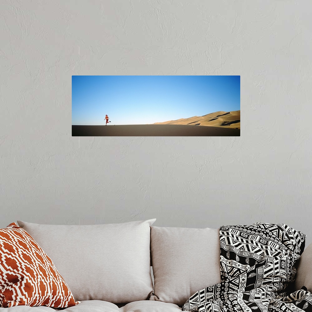 A bohemian room featuring Rear view of a woman running in the desert, Great Sand Dunes National Monument, Colorado