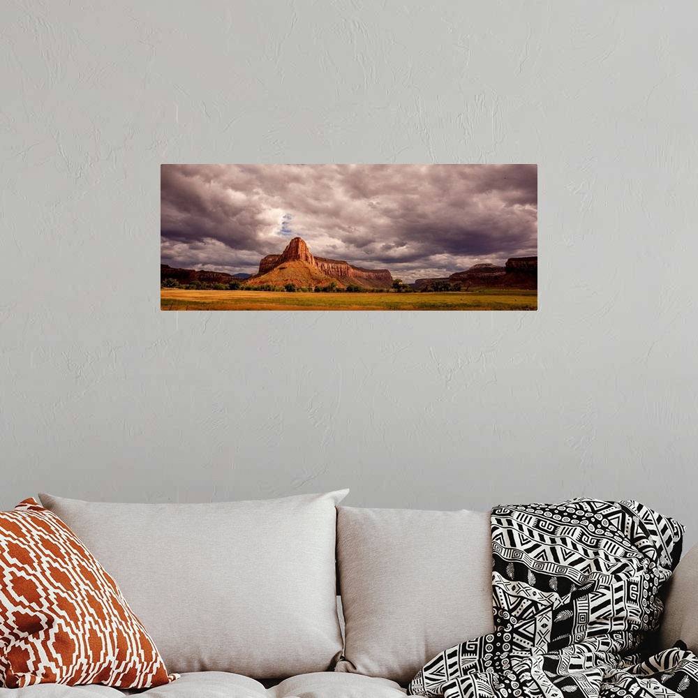 A bohemian room featuring Landscape photograph of large rock formations under a cloudy sky.