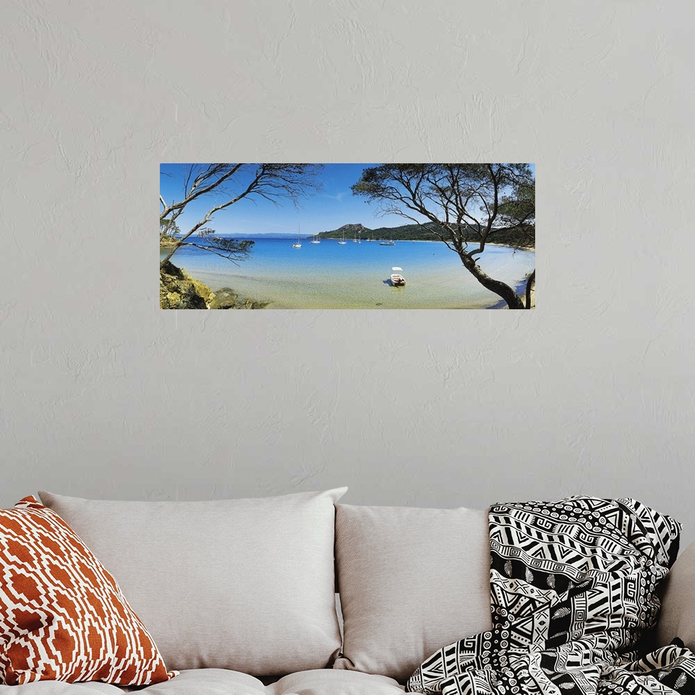 A bohemian room featuring This panoramic shot was taken looking out at a lagoon with boats in the water and trees on both s...