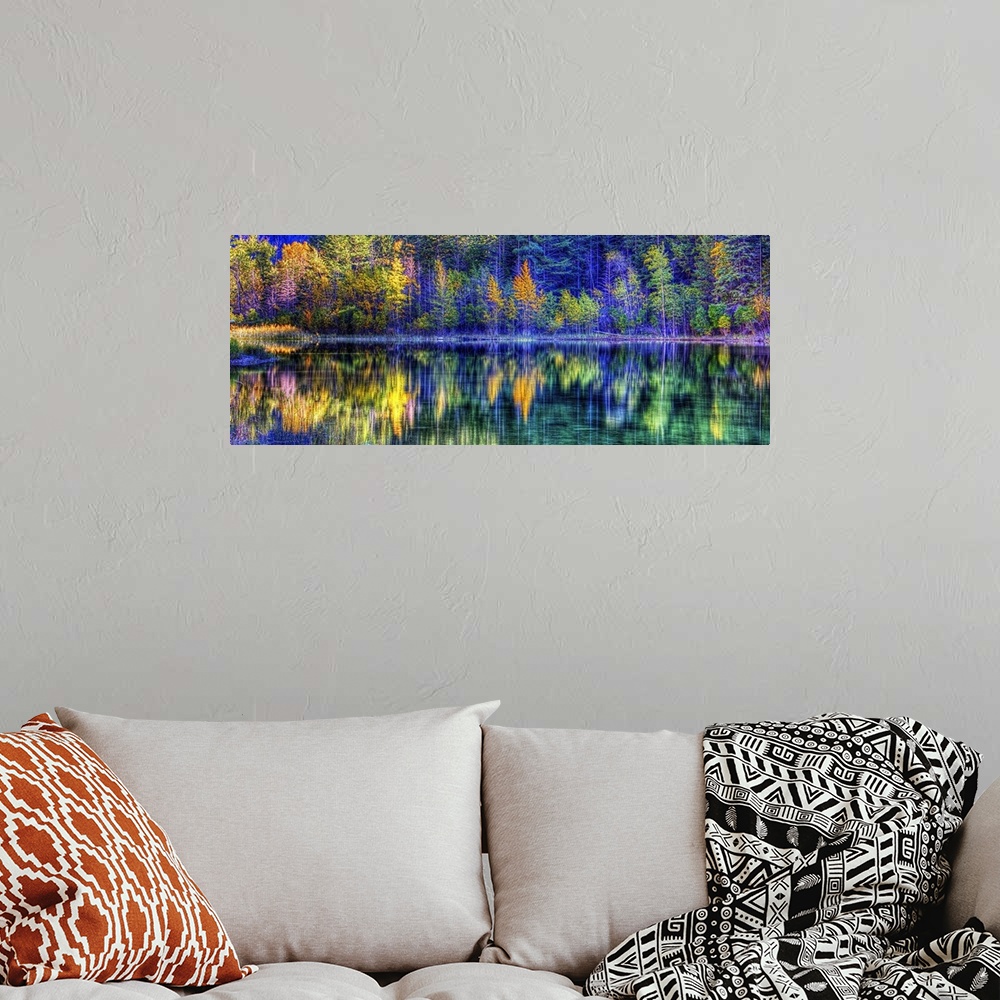 A bohemian room featuring A colorful scene of fall trees reflecting on the water.