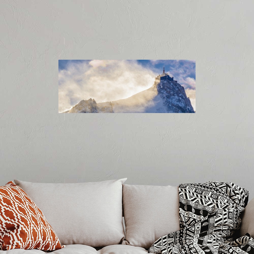 A bohemian room featuring Landscape photograph of a peak on Mont Blanc with hazy clouds.