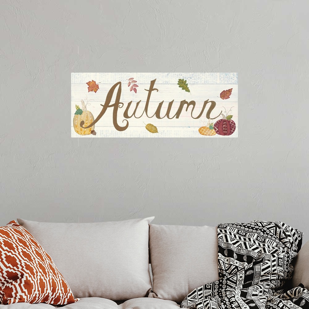 A bohemian room featuring Decorative artwork of the word "Autumn" with fall leaves and pumpkins and a white wood background.