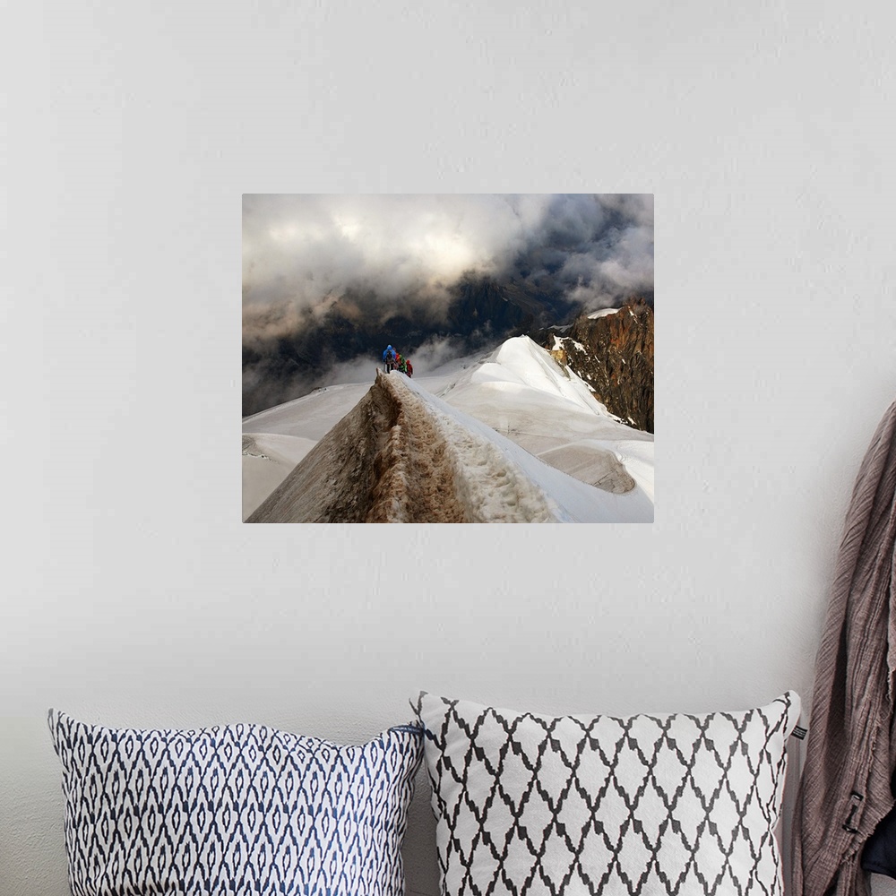 A bohemian room featuring Mountain climbers trekking across a snowy peak on their way to mountains obscured by clouds.