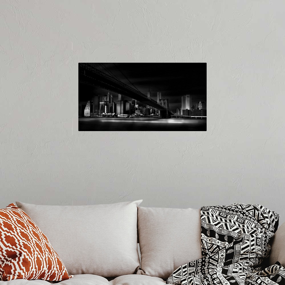 A bohemian room featuring A dramatic black and white photograph of the New York city skyline with the Brooklyn bridge in th...