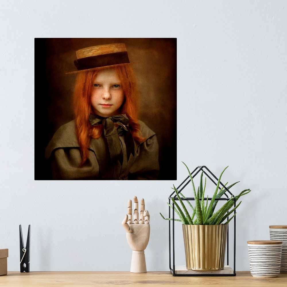 A bohemian room featuring A child with long red hair wearing a straw hat and a ribbon tied in a bow.
