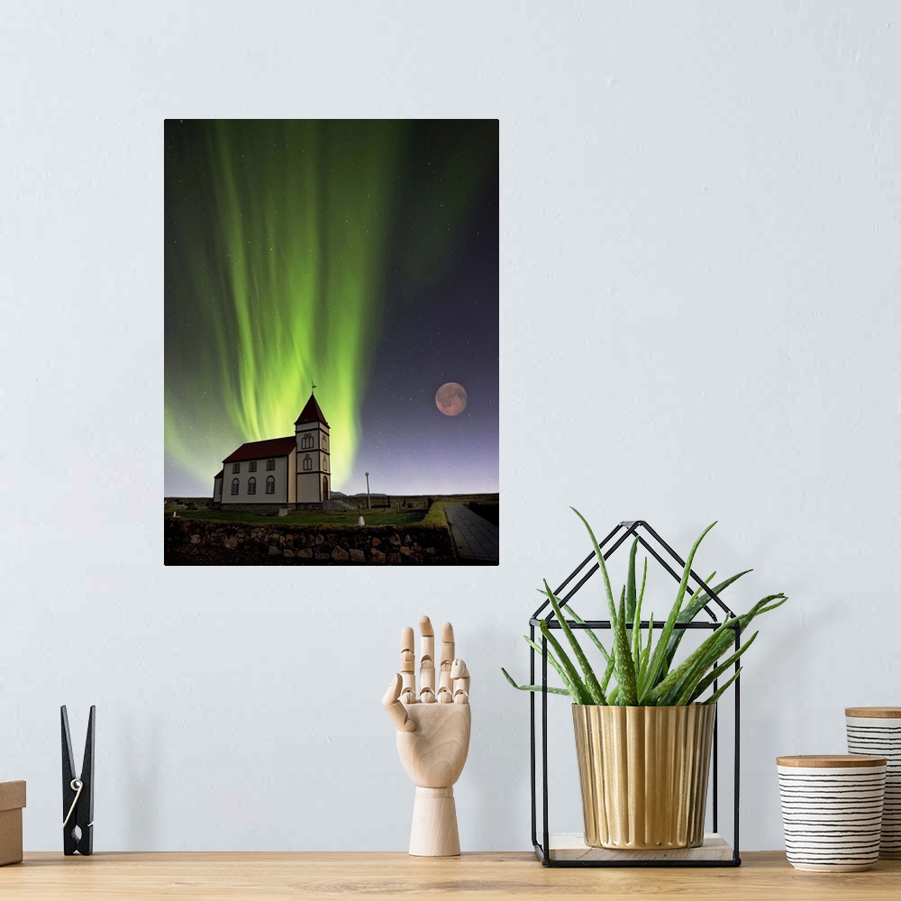 A bohemian room featuring A church with a red roof and the lights of the aurora borealis glowing in the sky overhead, with ...