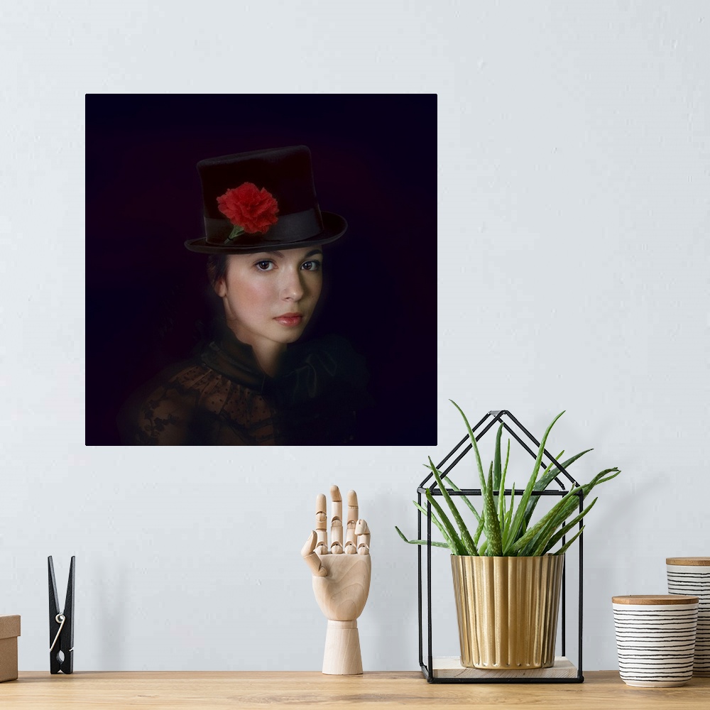 A bohemian room featuring Portrait of a lovely young woman wearing a top hat decorated with a red carnation.