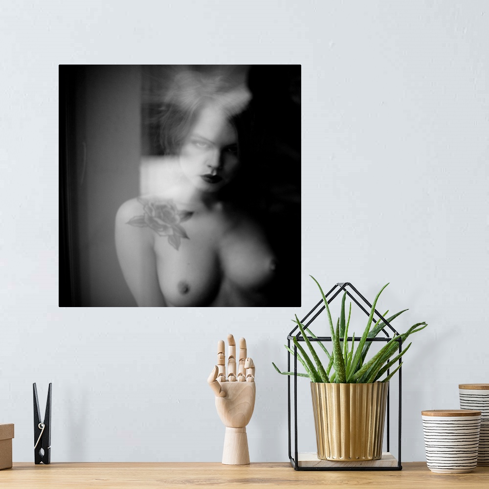 A bohemian room featuring Soft focus black and white portrait of a nude woman from the chest up with a rose tattoo.
