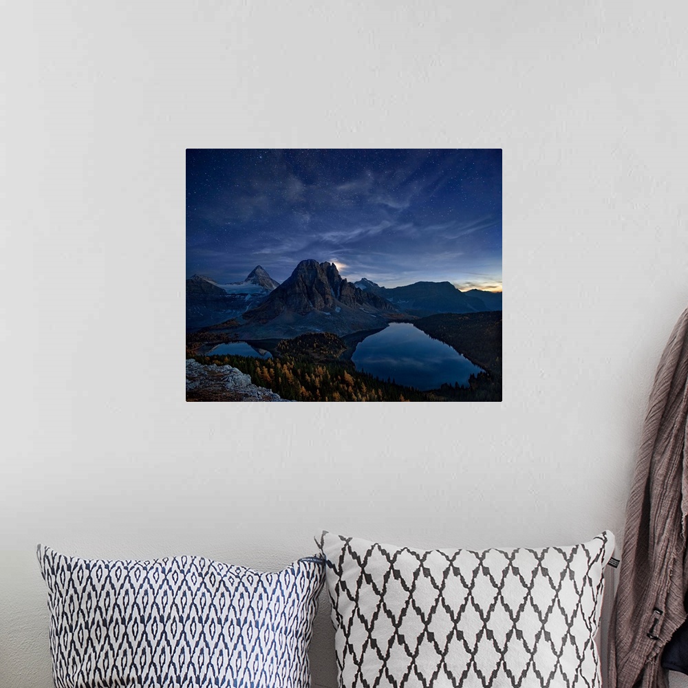 A bohemian room featuring Mount Assiniboine in the Canadian Rockies at night, under a starry sky.