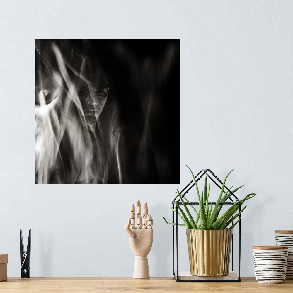 A bohemian room featuring Square black and white surreal photograph of a man's face in the background with abstract smoke a...