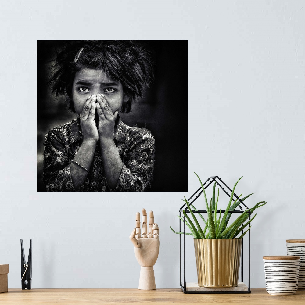 A bohemian room featuring Black and white portrait of a young girl holding her hands to her face.