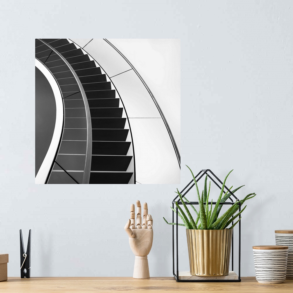 A bohemian room featuring Black and white image of a staircase curving around.