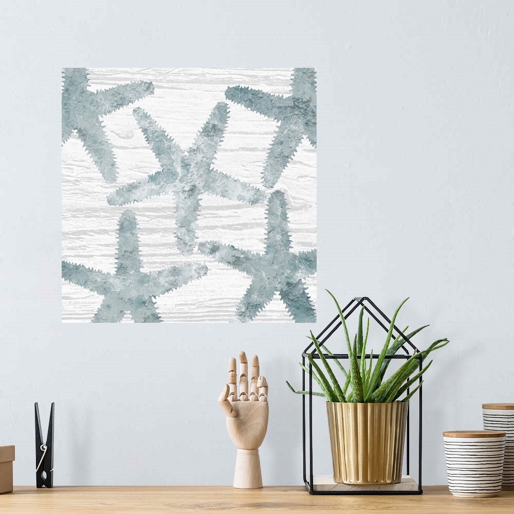 A bohemian room featuring Square watercolor painting of blue starfish on a white wood grain background.