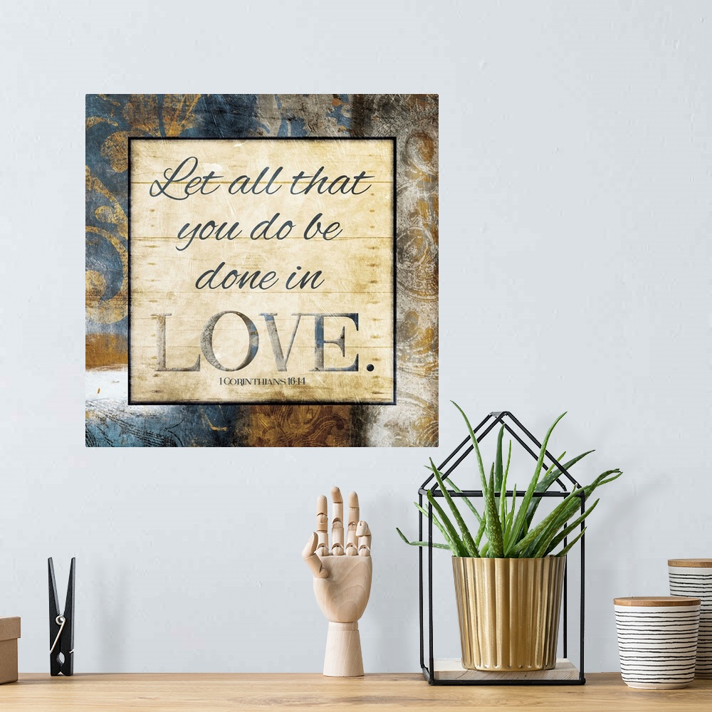 A bohemian room featuring Typography art of the Bible verse 1 Corinthians 16:14 framed with classic style gold and blue flo...