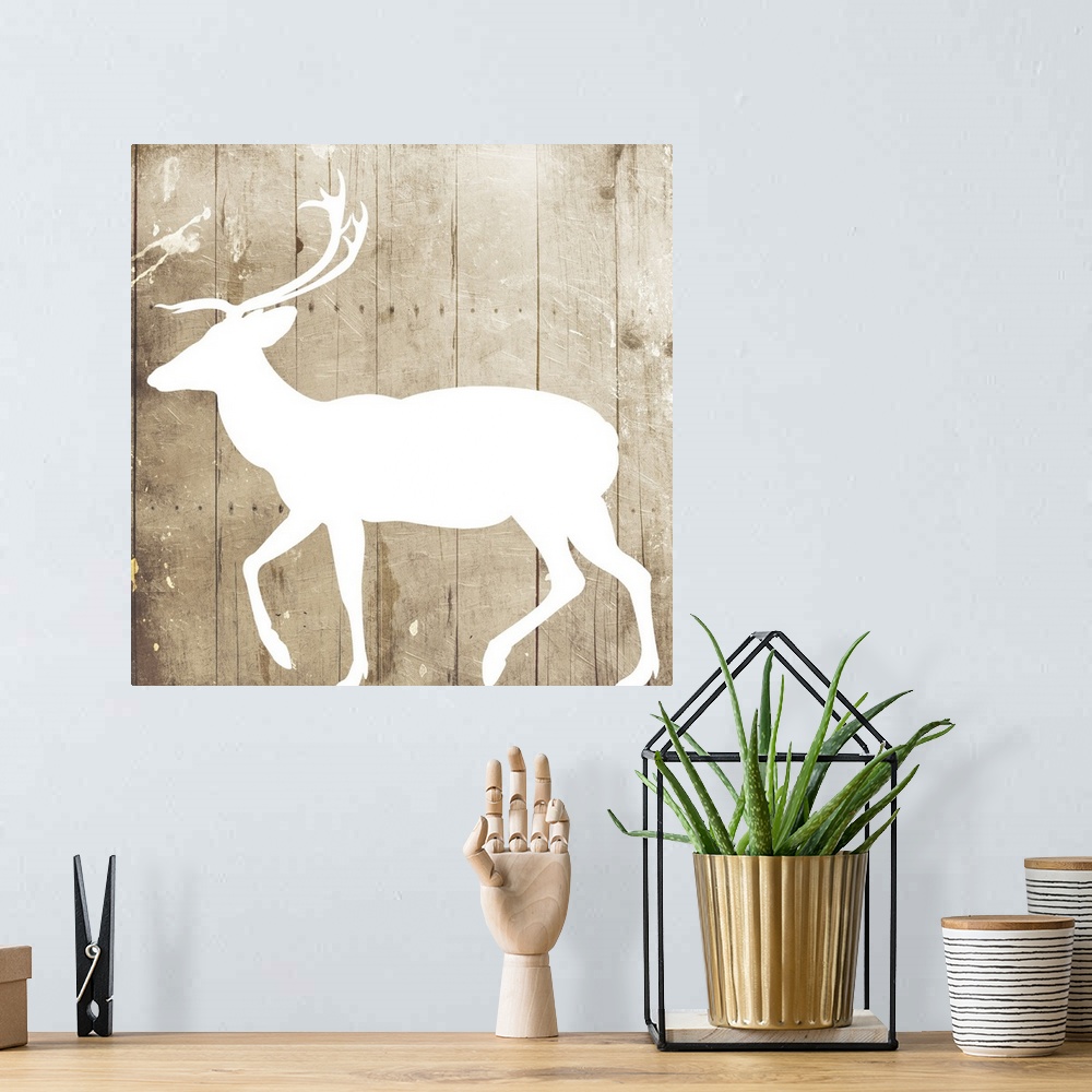 A bohemian room featuring A white silhouette of a deer painted on a wood background.