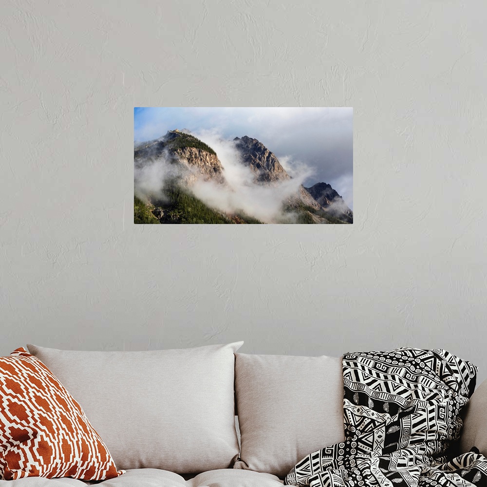 A bohemian room featuring Clouds gather around rocky mountain peaks, field, British Columbia, Canada.