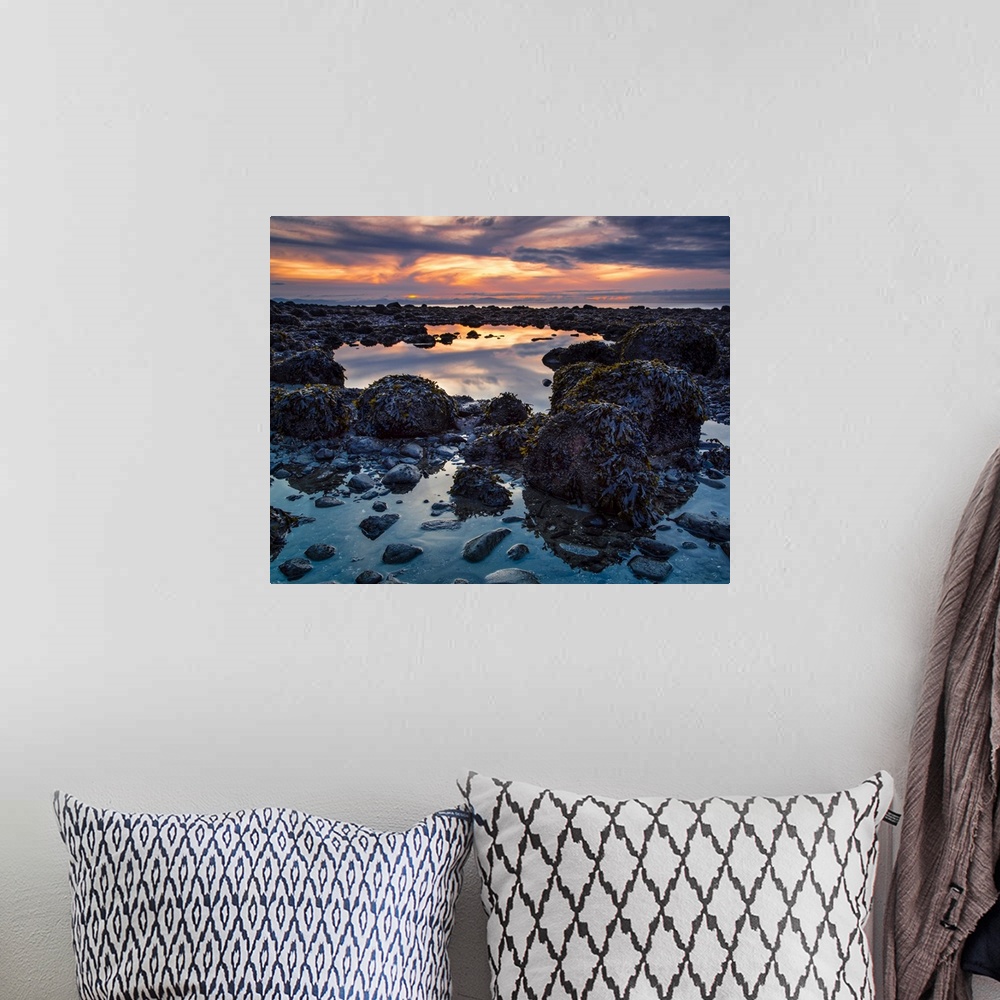 A bohemian room featuring Warm colours from a sunset sky reflect in the tide pools on Acadia Beach; Vancouver, British Colu...