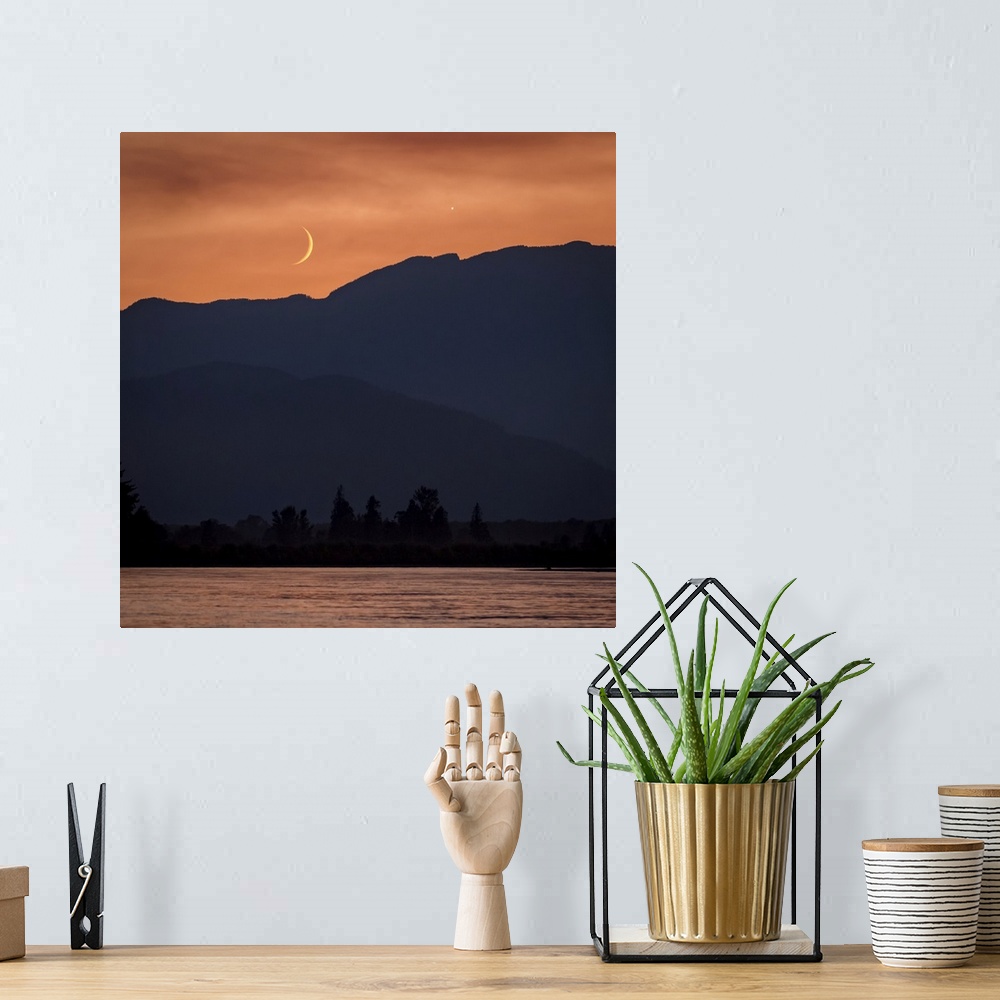 A bohemian room featuring The moon and Venus in an orange sky over the silhouetted mountains, Fraser Valley; Vancouver, Bri...
