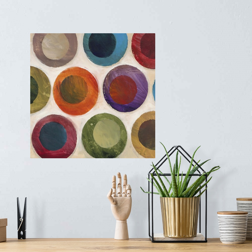 A bohemian room featuring Contemporary abstract painting of multi-colored circles against a beige background.