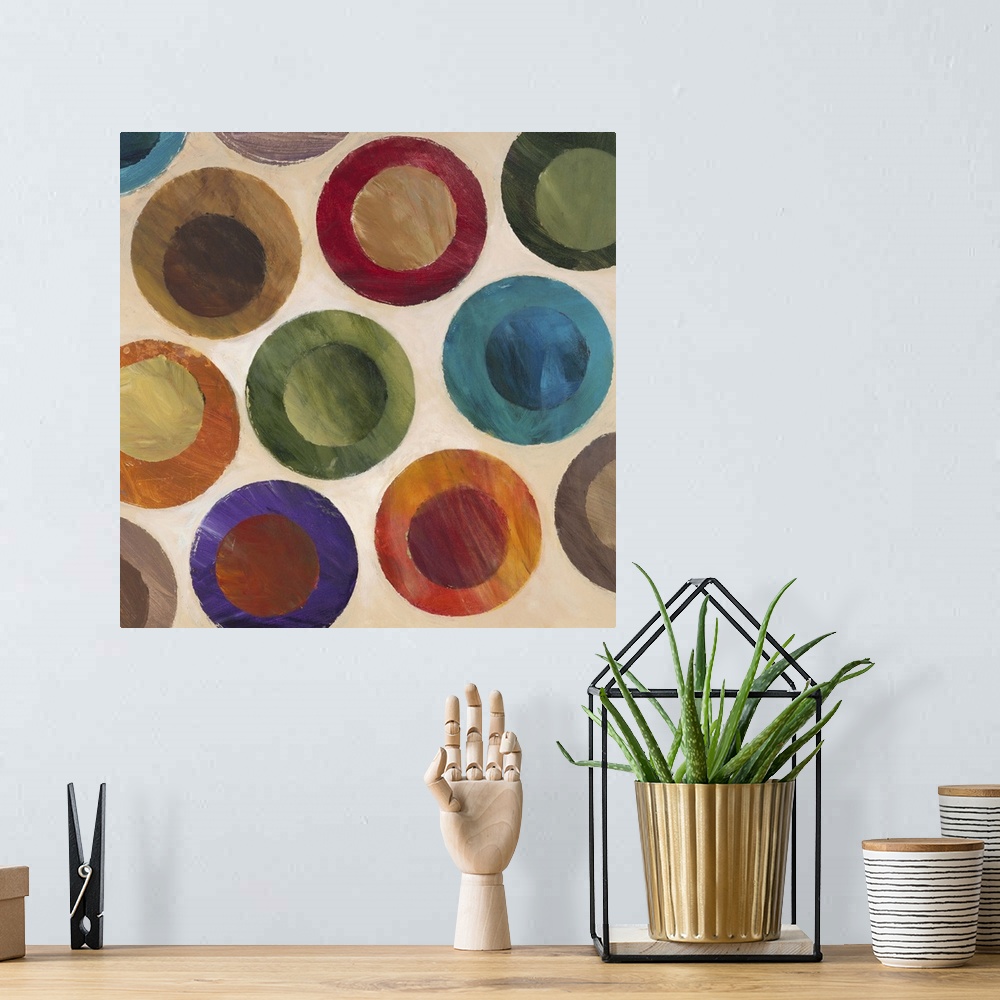 A bohemian room featuring Contemporary abstract painting of multi-colored circles against a beige background.