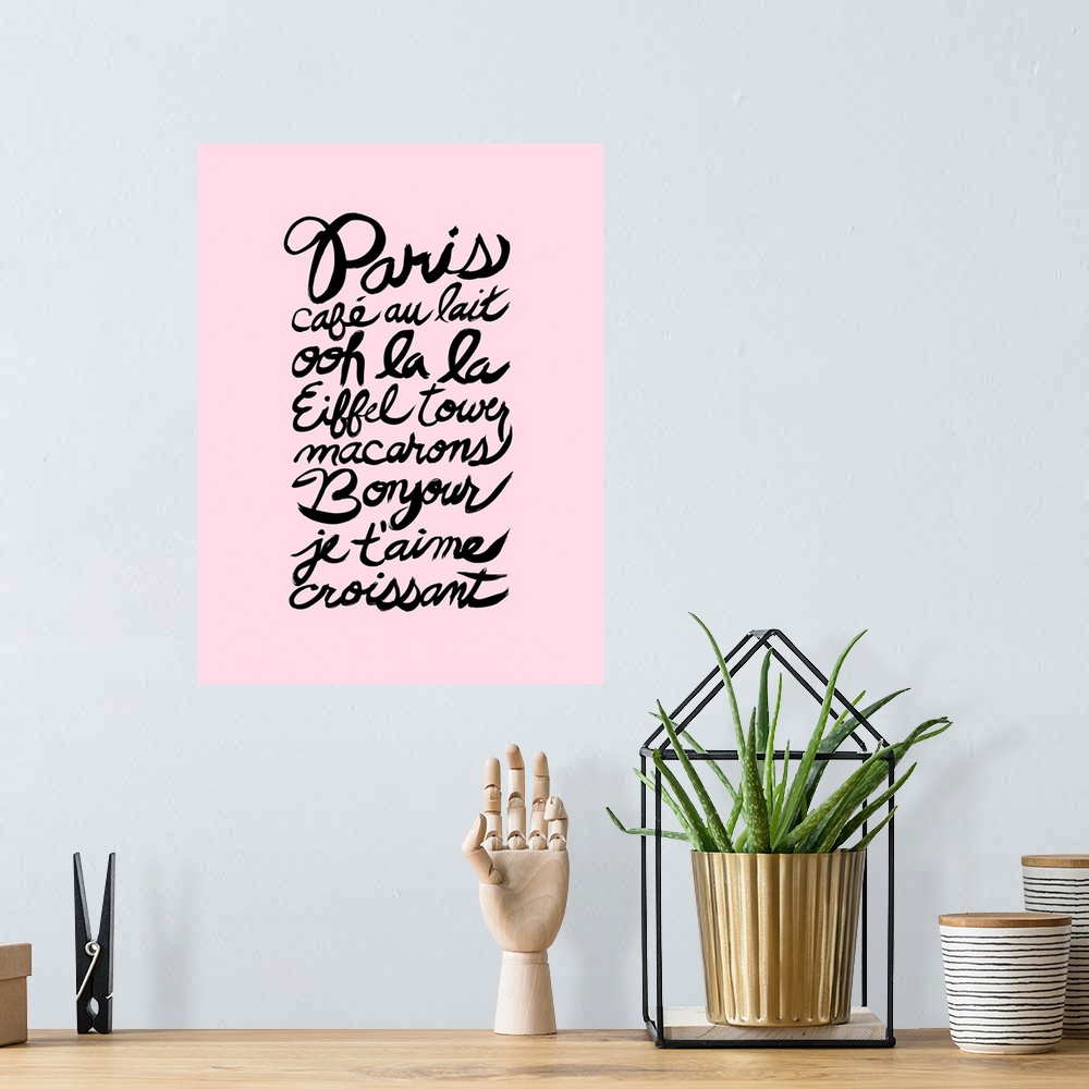 A bohemian room featuring Paris themed French words hand lettered in black on a pastel pink background.