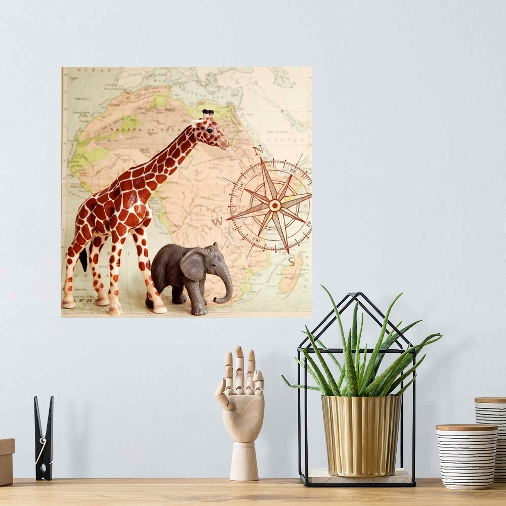 A bohemian room featuring A toy elephant and giraffe with a vintage map backdrop.