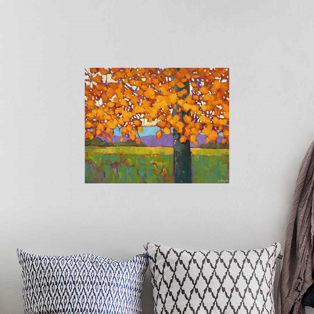 A bohemian room featuring A tree with bright orange leaves in the fall.