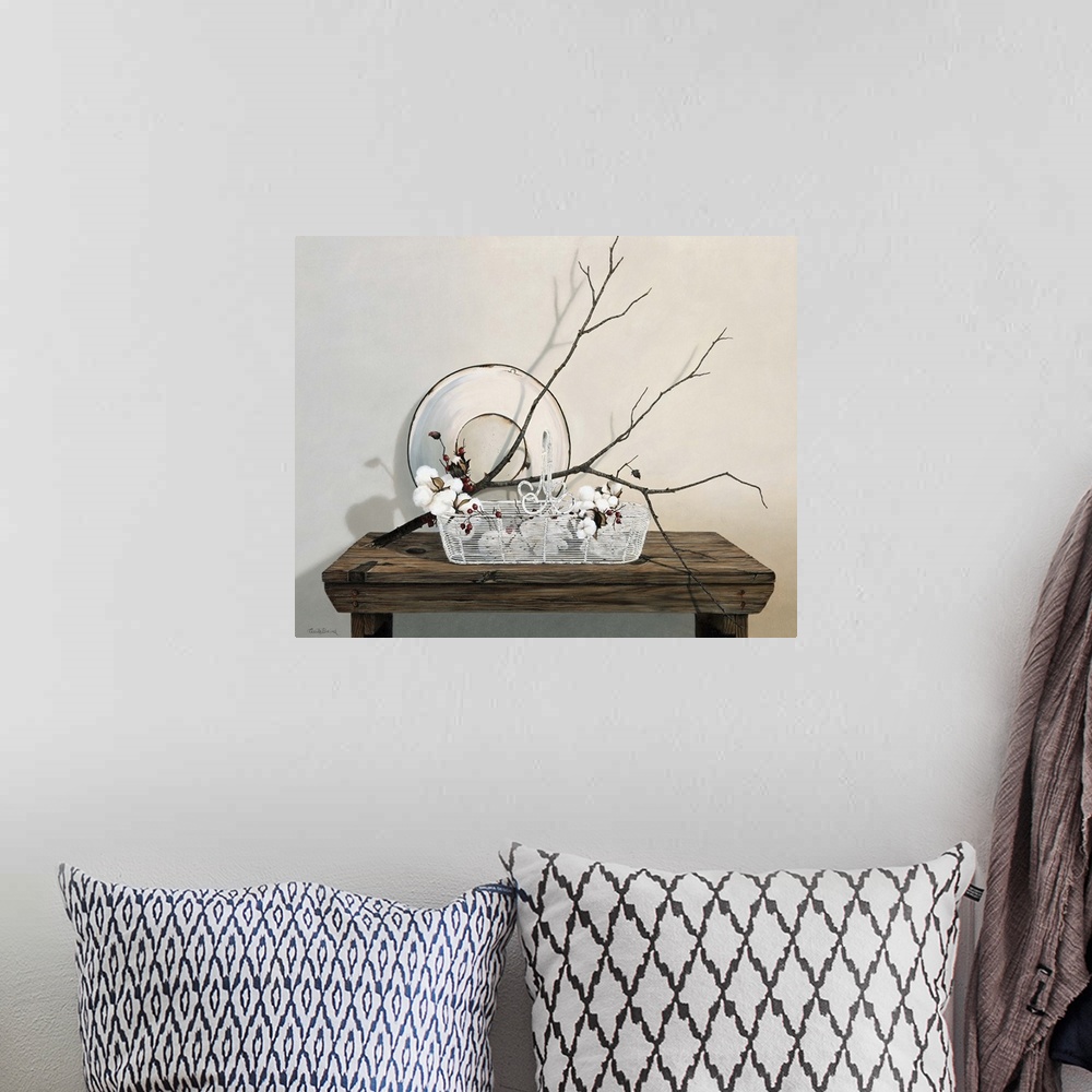 A bohemian room featuring Wire basket on table with branch of cotton.