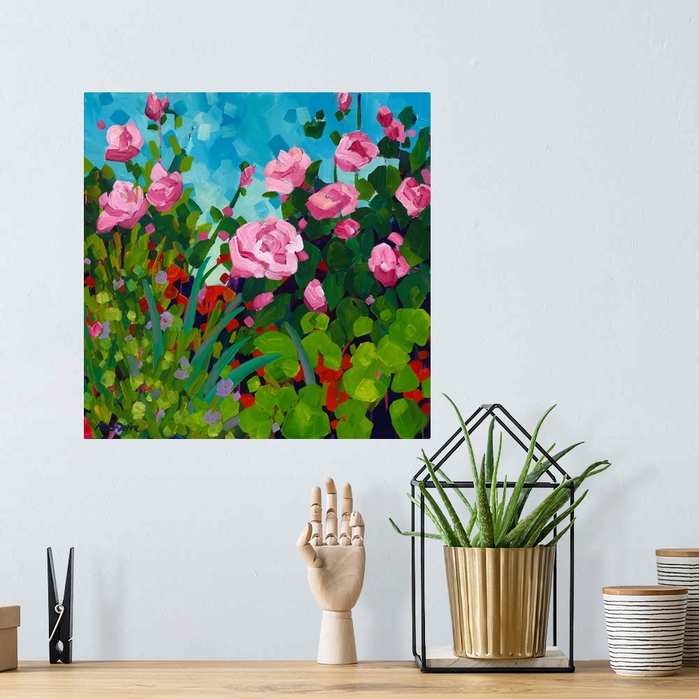 A bohemian room featuring Pink roses and red flowering geranium painting in front of a blue sky.