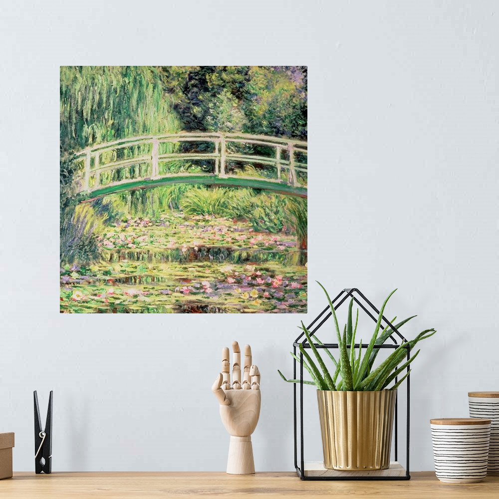 A bohemian room featuring This classic artwork is a painting of a small walking bridge over water that is covered with lily...