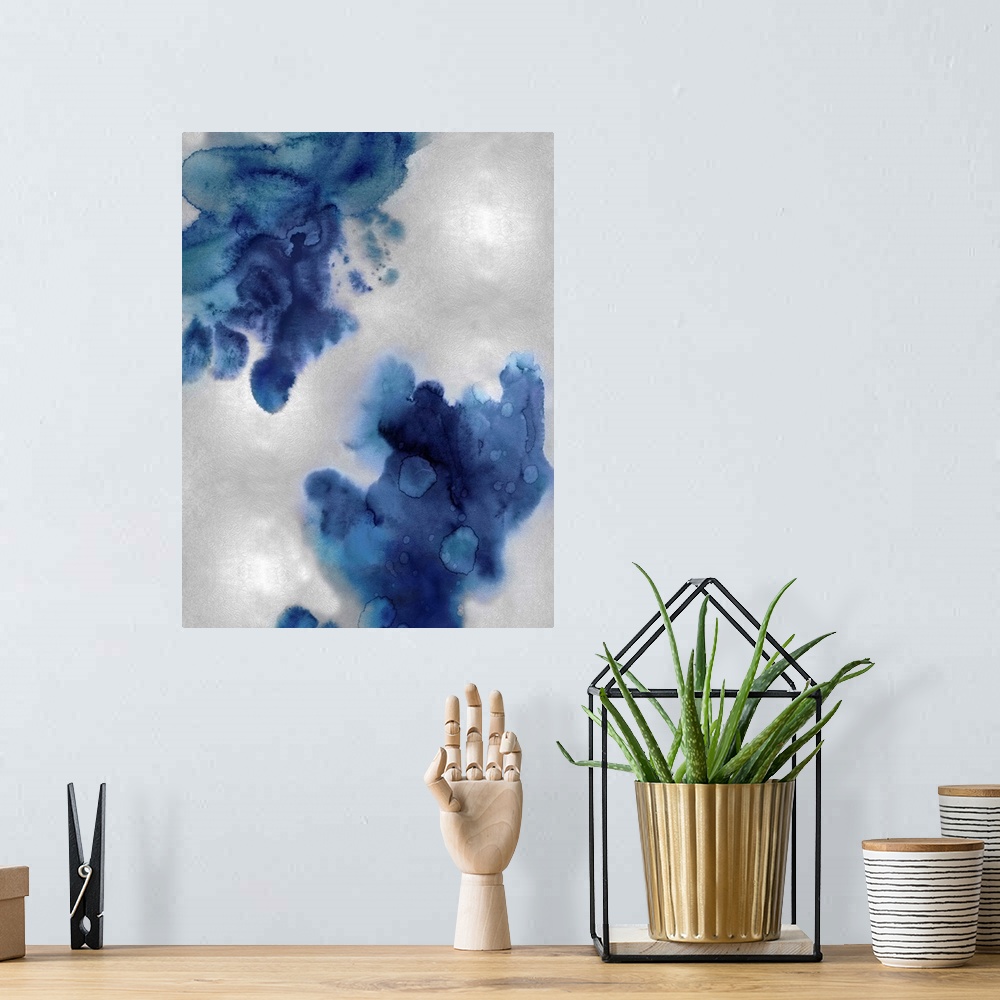 A bohemian room featuring Abstract painting with indigo hues splattered together on a silver background.