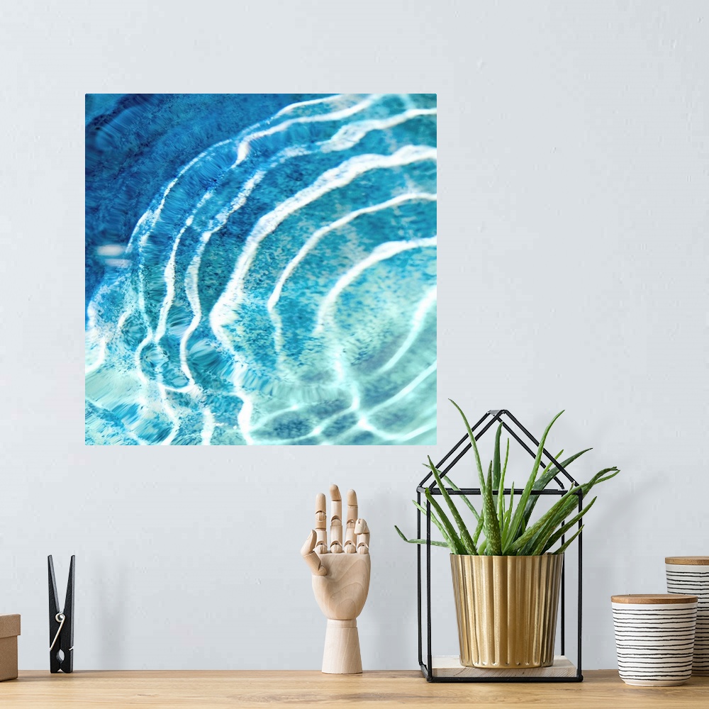 A bohemian room featuring Square photograph of ripples in clear blue water.