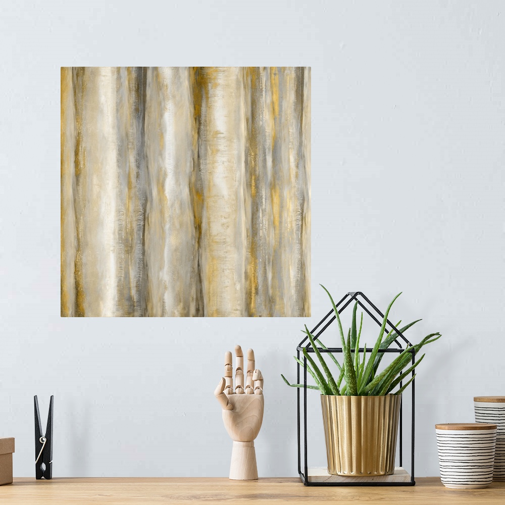 A bohemian room featuring Square abstract painting with bands of metallic gold and silver running vertically across the can...