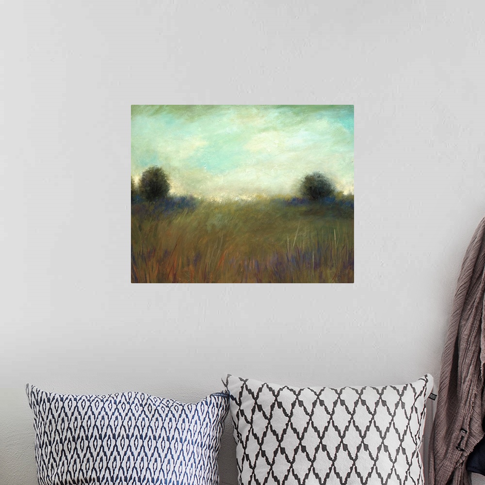 A bohemian room featuring A muted contemporary painting of tall grass in a field with a line of trees in the background.