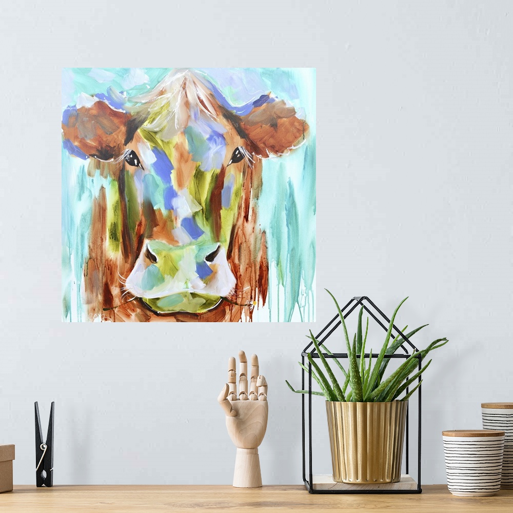 A bohemian room featuring A contemporary square painting of the face of a cow done in multiple colors with strokes of blue ...