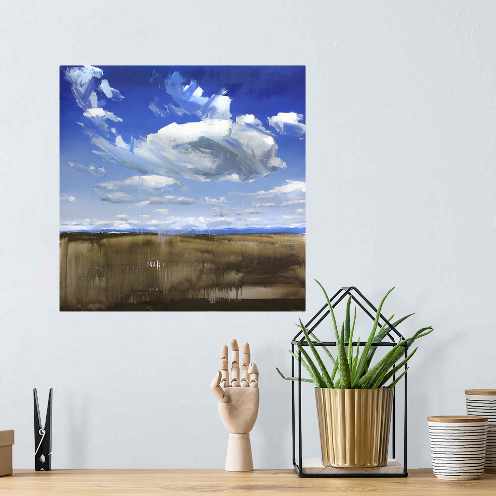 A bohemian room featuring A contemporary painting of a green field under a sky filled with gray clouds.