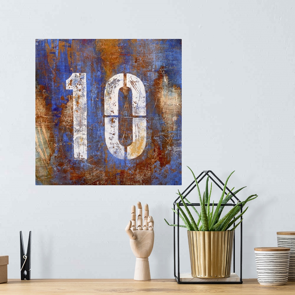 A bohemian room featuring Square abstract painting on canvas of a stenciled number ten on top of blotches of color.