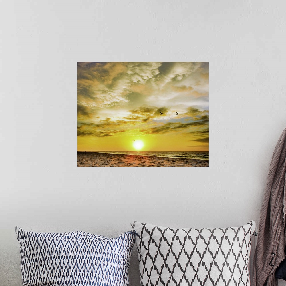 A bohemian room featuring A beautiful Destin Beach Sunrise with orange and white clouds.