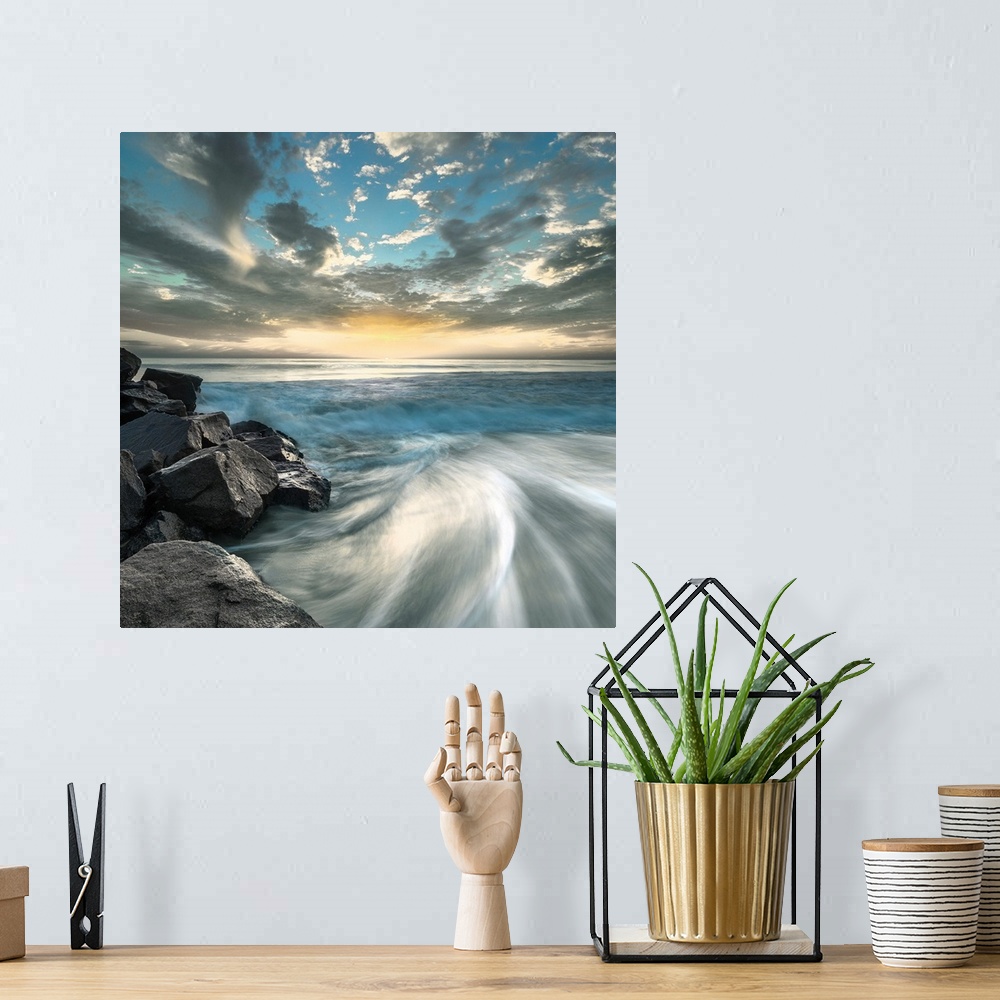 A bohemian room featuring Long exposure photograph of ocean waves crashing on a rocky beach shore with a dramatic sky.