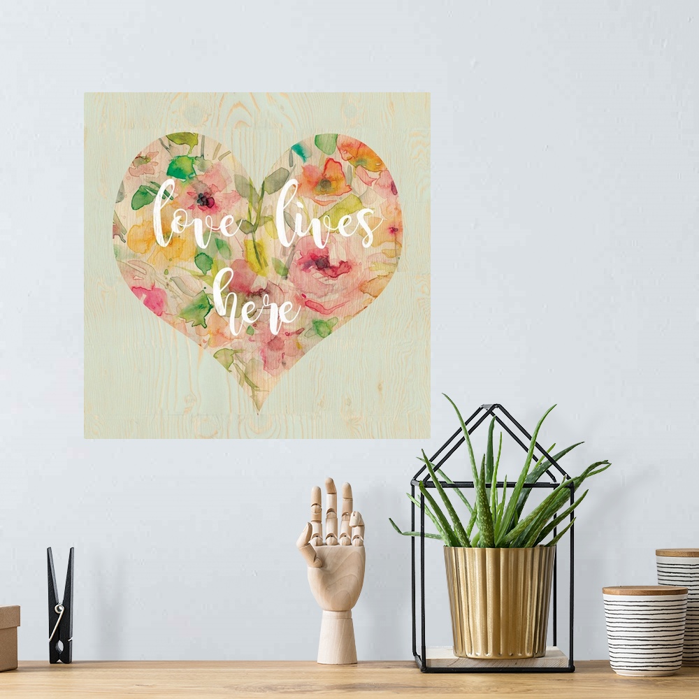A bohemian room featuring "Love Lives Here" written in white script inside a heart filled with watercolor flowers, all on a...